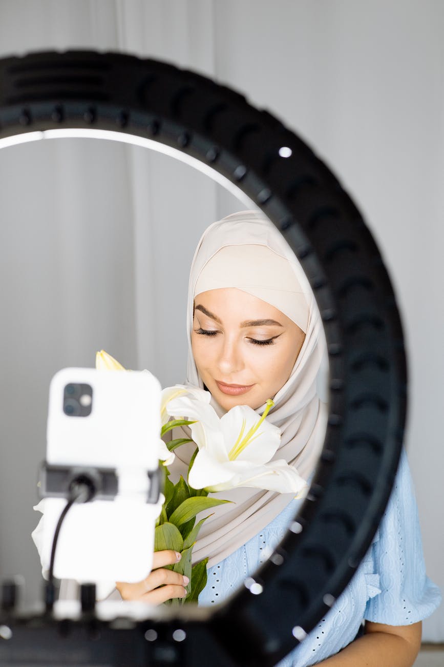 a woman wearing hijab while holding white flowers